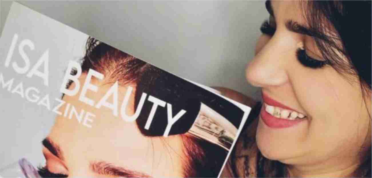 Isa, fondatrice di Isa Beauty Magazine, mentre sorride e tiene in mano la copertina della rivista