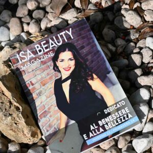 Copertina di Isa Beauty Magazine con un primo piano di Isa che sorride e applica prodotti di bellezza, in un ambiente naturale